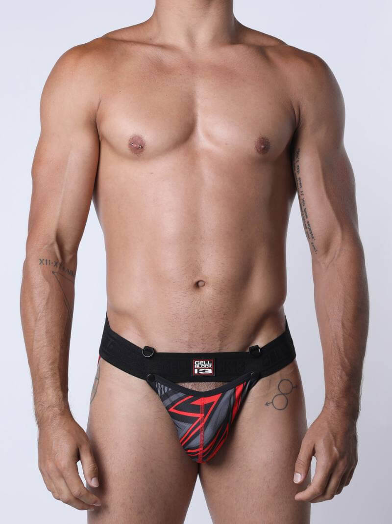 Man wearing a black and red athletic jockstrap on a white background