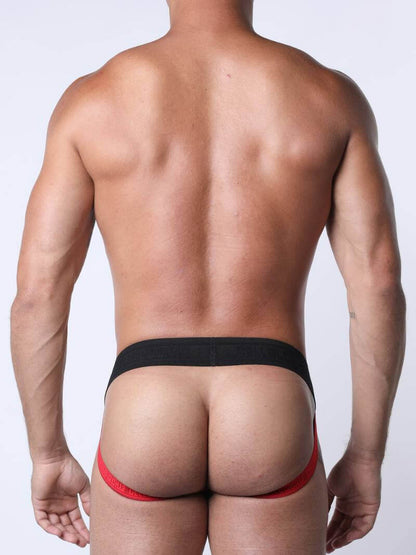 Man wearing a red and black thong against a plain background
