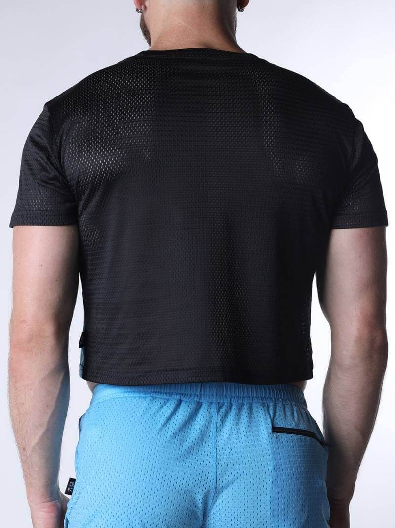 Person wearing a black athletic shirt and blue shorts on a white background