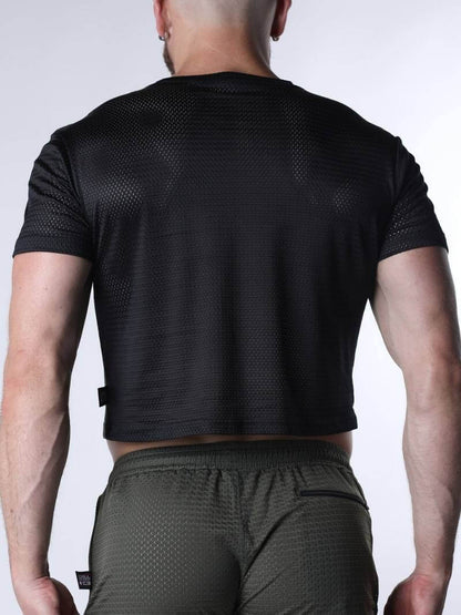 Person wearing a black athletic shirt and green shorts on a white background