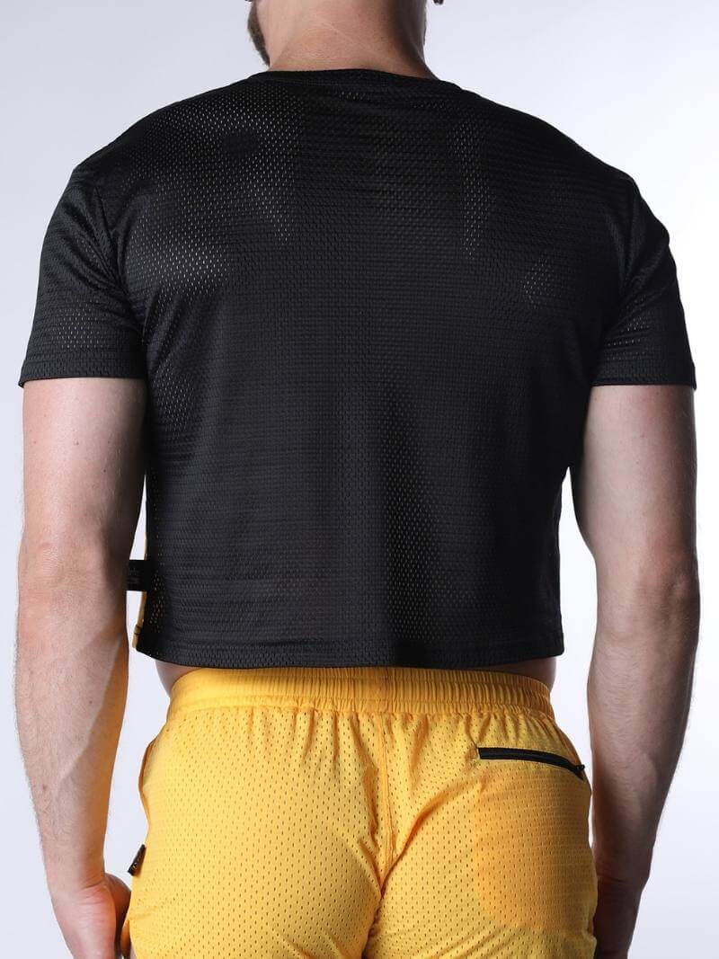 Person wearing a black athletic shirt and yellow shorts on a white background