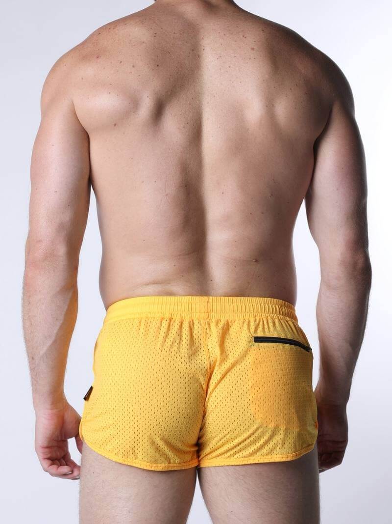 Person wearing yellow shorts on a white background