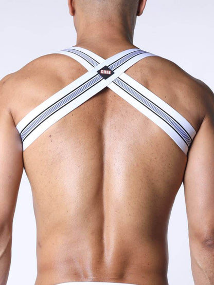 Man wearing a white harness with black straps on a plain background