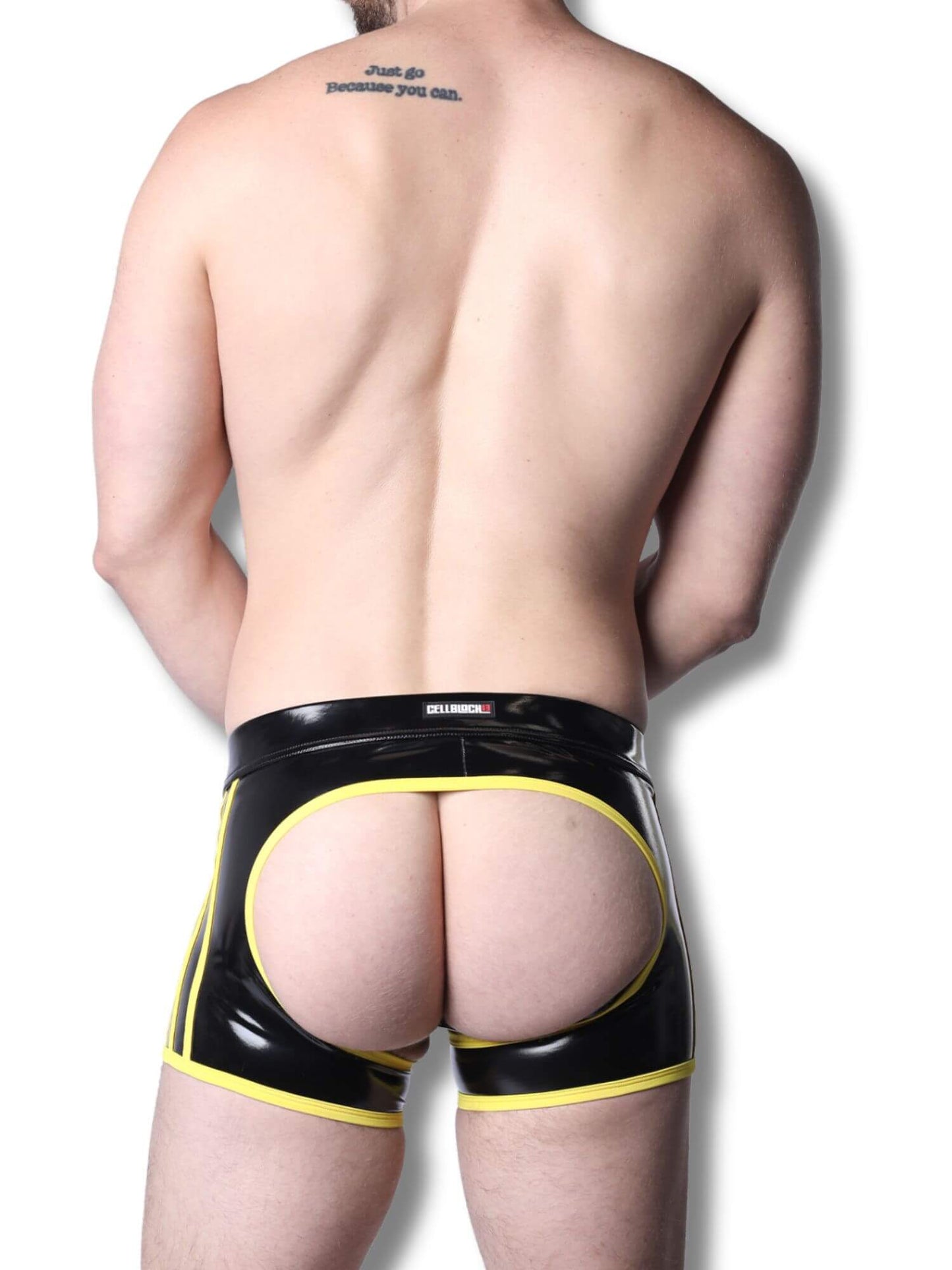 Man wearing black and yellow latex underwear on a white background