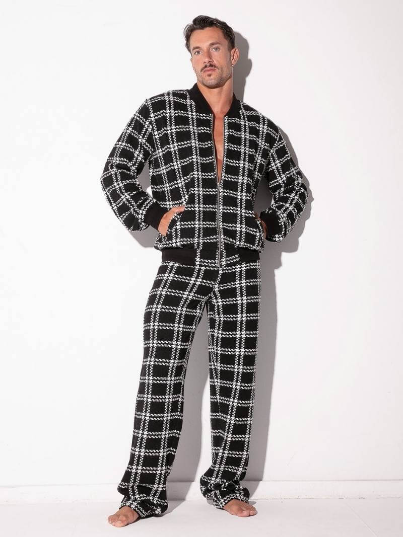 Man wearing a black and white checkered pajama set on a white background