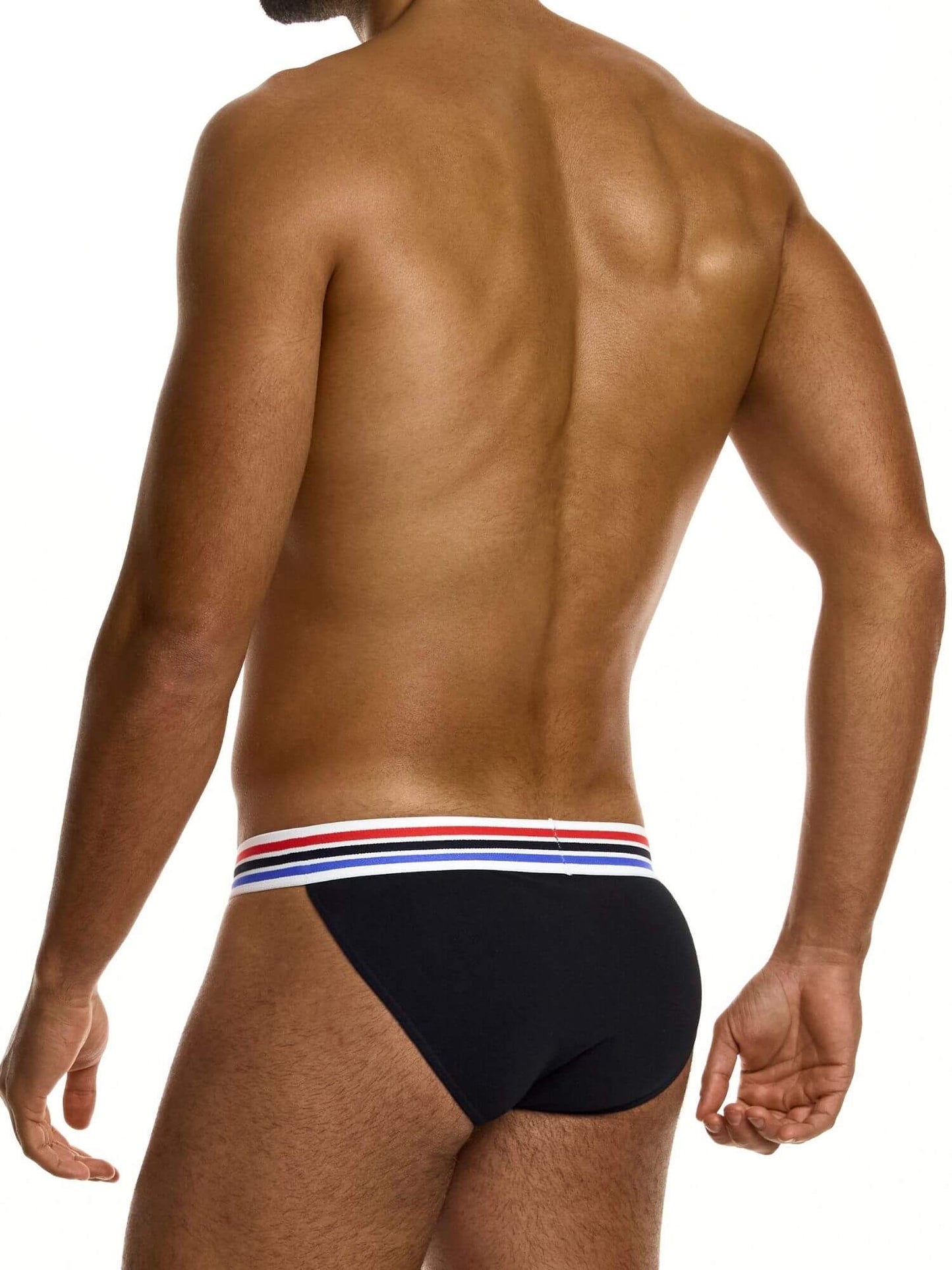 Man wearing black tanga brief with a red, white, and blue striped waistband on a white background