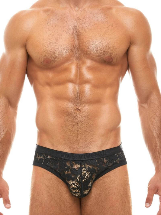 Man wearing black lace underwear on a white background