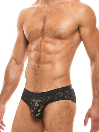 Man wearing black lace underwear on a white background