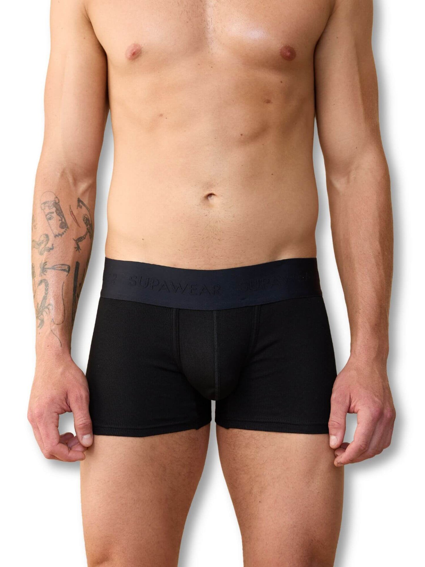 Man wearing black boxer briefs with a visible brand logo on a white background